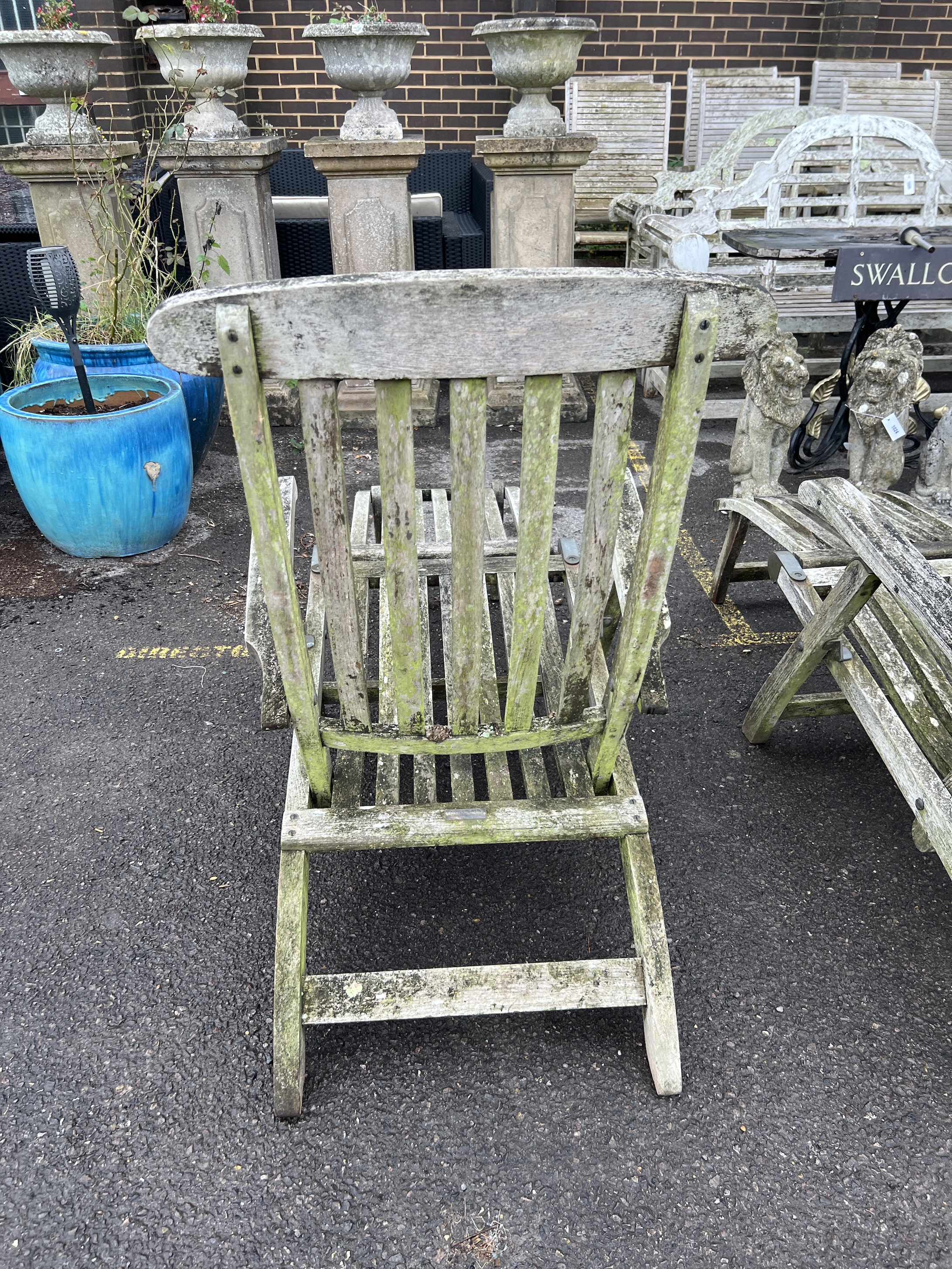 A pair of Barlow Tyrie weathered teak garden steamer chairs, width 60cm, height 96cm